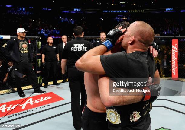 Georges St-Pierre of Canada hugs Michael Bisping of England in their UFC middleweight championship bout during the UFC 217 event at Madison Square...