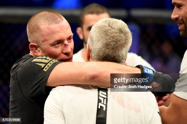 Georges St-Pierre of Canada celebrates with trainer Freddie Roach following hs victory over Michael Bisping of England in their UFC middleweight...