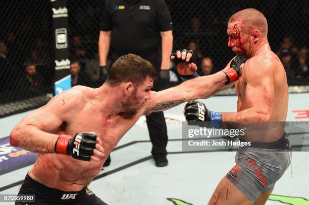 Michael Bisping of England lands a punch against Georges St-Pierre of Canada in their UFC middleweight championship bout during the UFC 217 event at...