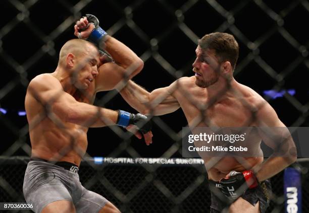 Michael Bisping of England lands a punch against Georges St-Pierre of Canada in their UFC middleweight championship bout during the UFC 217 event at...