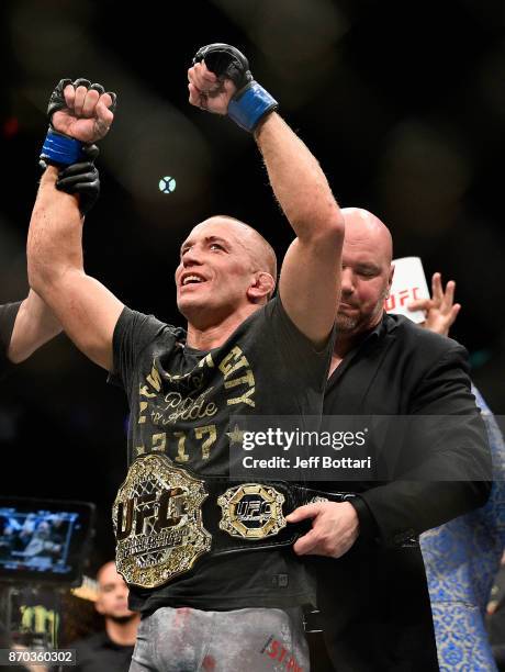 Georges St-Pierre of Canada accepts his championship belt after defeating Michael Bisping of England in their UFC middleweight championship bout...