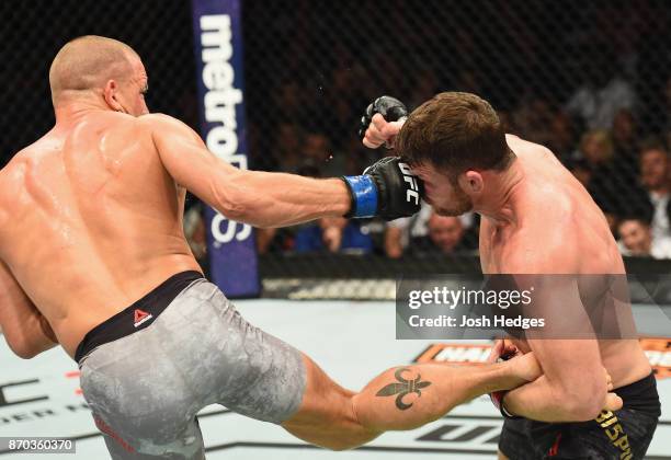 Georges St-Pierre of Canada punches Michael Bisping of England in their UFC middleweight championship bout during the UFC 217 event at Madison Square...