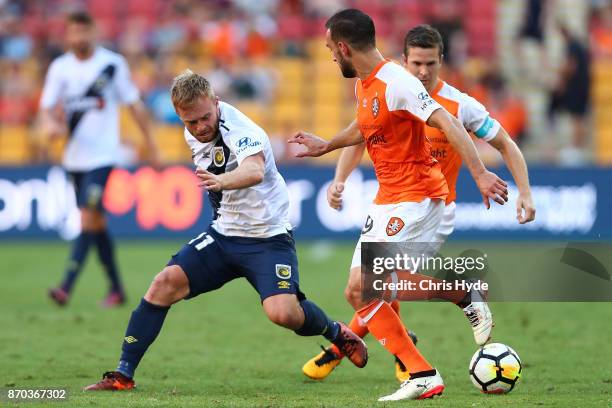 Matthew McKay of the Roar and Connor Pain of the Glory compete for the ball during the round five A-League match between the Brisbane Roar and the...