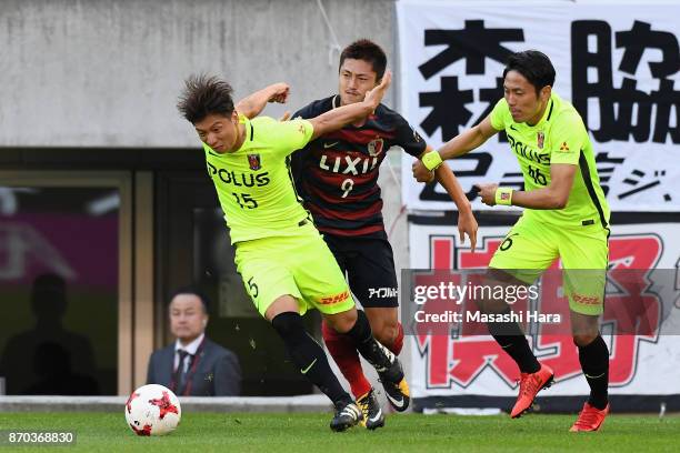 Yuma Suzuki of Kashima Antlers controls the ball under pressure of Kazuki Nagasawa and Ryota Moriwaki of Urawa Red Diamonds during the J.League J1...