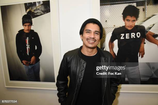 Photographer/musician Jonathan Velasquez poses with his portraits by Larry Clark during the Larry Clark and Jonathan Velasquez Photo Exhibition as...