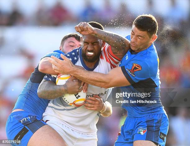 Eddy Pettybourne of the USA is tackled by Mark Minichiello and Nathan Milone of Italy during the 2017 Rugby League World Cup match between Italy and...