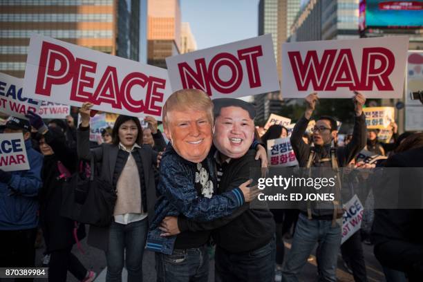 Demonstrators dressed as North Korean leader Kim Jong-Un and US President Donald Trump embrace during a peace rally in Seoul on November 5, 2017. -...