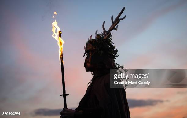 Man representing the Winter King holds a flaming sword as he takes part in a ceremony as they celebrate Samhain at the Glastonbury Dragons Samhain...