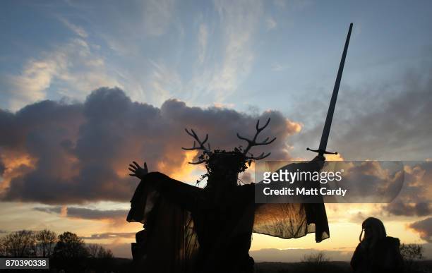 Man representing the Winter King holds a sword as he takes part in a sunset ceremony as they celebrate Samhain at the Glastonbury Dragons Samhain...