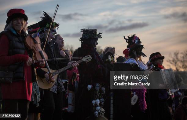 People take part in a sunset ceremony on the lower slopes of Glastonbury Tor as they celebrate Samhain at the Glastonbury Dragons Samhain Wild Hunt...