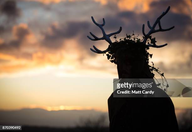 People take part in a sunset ceremony on the lower slopes of Glastonbury Tor as they celebrate Samhain at the Glastonbury Dragons Samhain Wild Hunt...