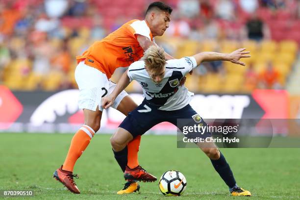 Andrew Hoole of the Mariners and Dane Ingham of the Roar compete for the ball during the round five A-League match between the Brisbane Roar and the...