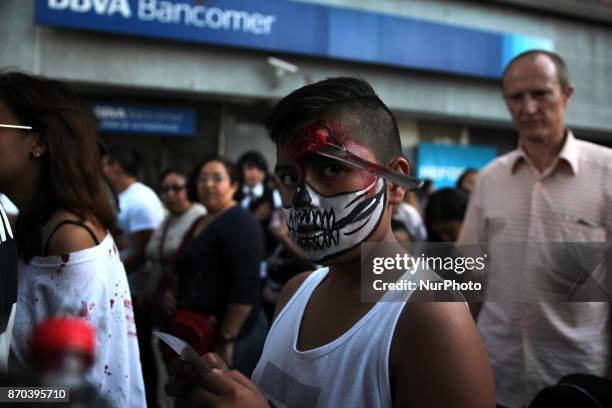 Boy is disguised as a Skull with a fork on his forhead walks during the annual procession of zombies in Mexico City on November 4, 2017. Hundreds...