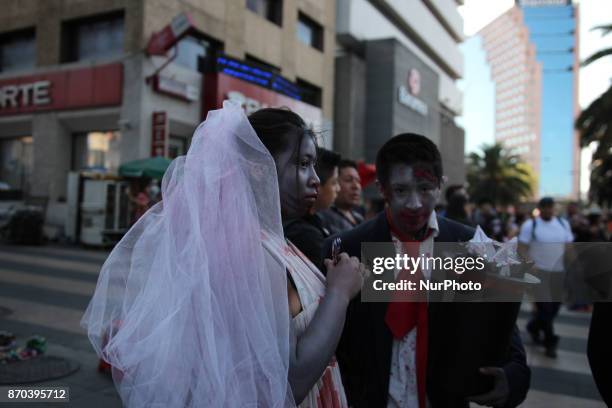 Couple dissgised as a zombie husband and bride during annual procession of zombies in Mexico City on November 4, 2017. Hundreds dressed in rags and...