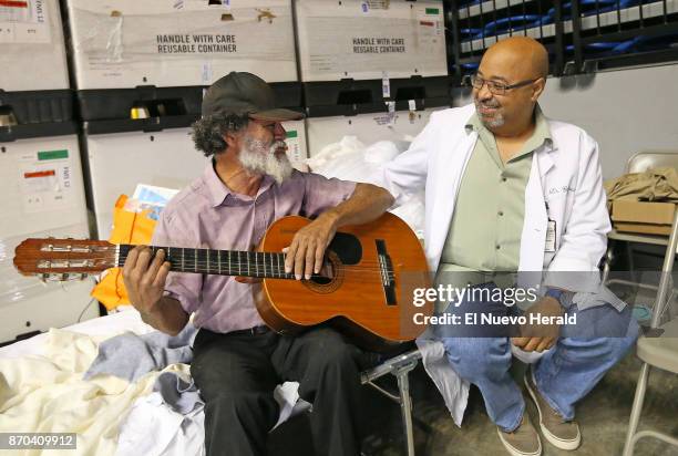 Santos Candelaria plays guitar and sings with Alfredo Guzman, MD VA Doctor from Oxford, Ala., and Natural de Villalba P.R., at the temporary hospital...