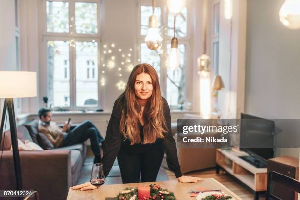 junge frau am esstisch mit weihnachtsdekoration - sitting at table looking at camera stock-fotos und bilder