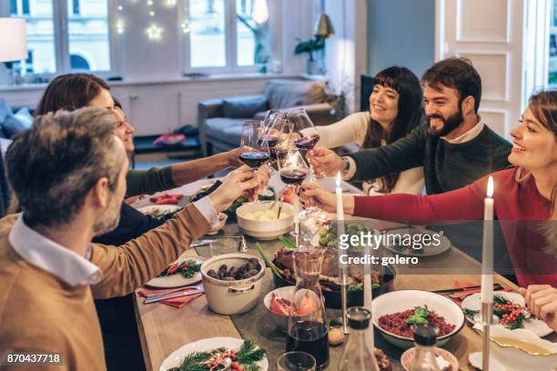 vrienden rammelende wijnglazen aan feestelijke kerst tafel