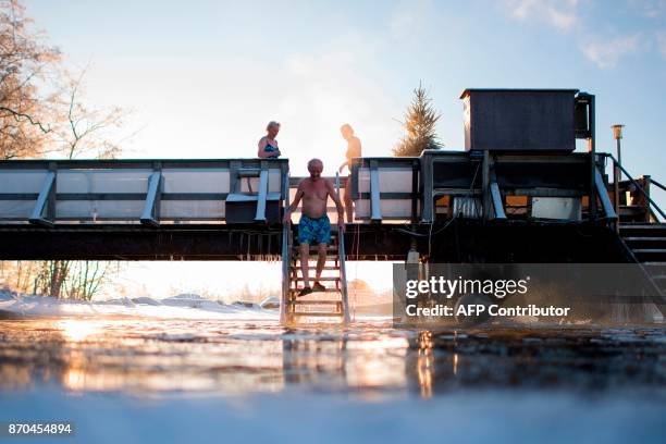 Finns take a dip in an unfrozen hole of water after a sauna session on January 15, 2017 in Vaasa, as air temperature is -17°C and water is +1°C. /...