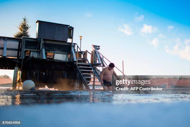 Finns take a dip in an unfrozen hole of water after a sauna session on January 15, 2017 in Vaasa, as air temperature is -17°C and water is +1°C. /...