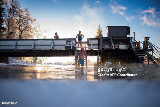 Finns take a dip in an unfrozen hole of water after a sauna session on January 15, 2017 in Vaasa, as air temperature is -17°C and water is +1°C. /...