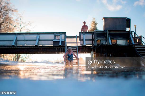 Finns take a dip in an unfrozen hole of water after a sauna session on January 15, 2017 in Vaasa, as air temperature is -17°C and water is +1°C. /...