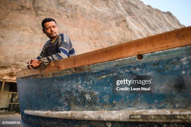Fisherman Wayne Yon takes a break from renovation work on his boat "Tina" on October 23, 2017 in Jamestown, Saint Helena. The waters around the...