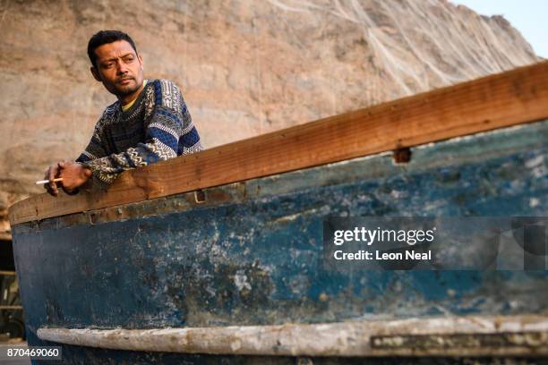 Fisherman Wayne Yon takes a break from renovation work on his boat "Tina" on October 23, 2017 in Jamestown, Saint Helena. The waters around the...