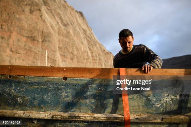 Fisherman Wayne Yon continues renovation work on his boat "Tina" on October 23, 2017 in Jamestown, Saint Helena. The waters around the island contain...