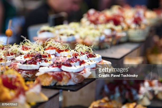 famous bilbao small sandwiches called pintxos server from a bar counter, blibao - bilbao stock pictures, royalty-free photos & images