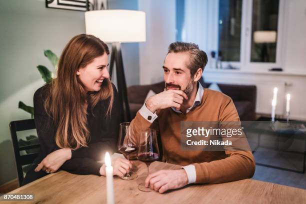 couple sitting on dining table during christmas party - candle light dinner stock pictures, royalty-free photos & images