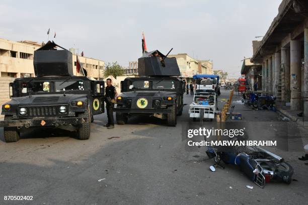 Iraqi security forces inspect the scene of a twin suicide attack at shopping area in Iraq's disputed Kirkuk city on November 5, 2017. - The attackers...