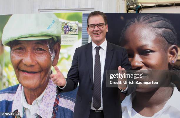 Climate Conference in Bonn. Dr. Gerd Mueller, Federal Minister for Economic, Cooperation and Development , between the portraits of two colored...