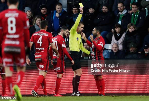 Saman Ghoddos of Ostersunds FK is shown a yellow card by Glenn Nyberg, referee during the Allsvenskan match between Jonkopings Sodra IF and...