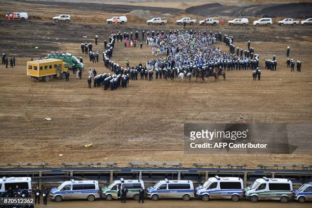 Policemen encircle environmentalists who managed to enter the Hambach lignite open pit mine near Elsdorf, western Germany, on November 5 during a...