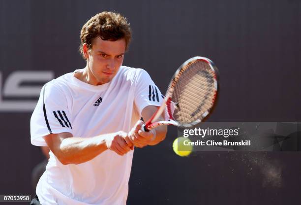 Ernests Gulbis of Latvia plays a backhand against Tommy Haas of Germany in their first round match during the Madrid Open tennis tournament at the...