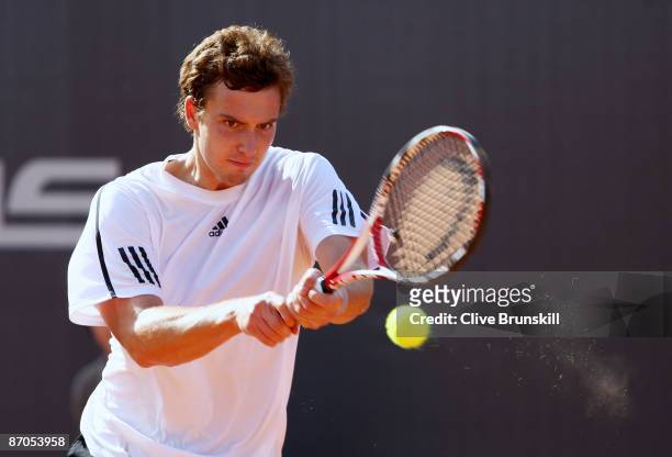 Ernests Gulbis of Latvia plays a backhand against Tommy Haas of Germany in their first round match during the Madrid Open tennis tournament at the...