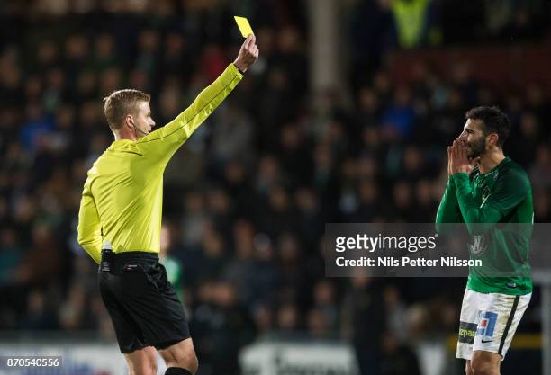Andre Calisir of Jonkopings Sodra is shown a yellow card by Glenn Nyberg, referee during the Allsvenskan match between Jonkopings Sodra IF and...