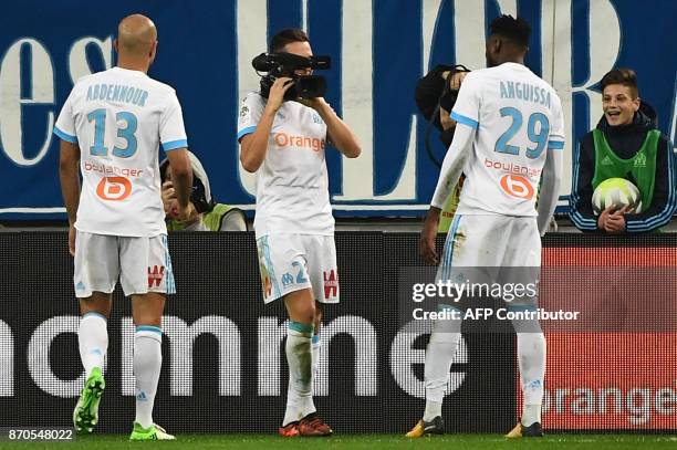 Olympique de Marseille's French midfielder Florian Thauvin films his teammates with a camera as he celebrates after scoring a goal, during the French...