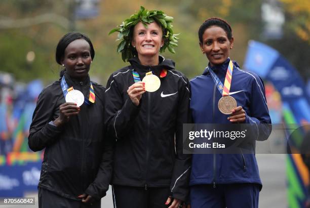 Shalane Flanagan of the United States celebrates winning the Professional Women's Division with Mary Keitany of Kenya and Mamitu Dasku of Ethiopia...