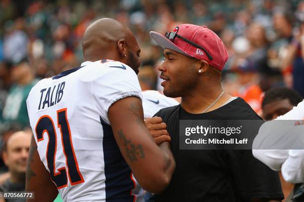 Cornerback Aqib Talib of the Denver Broncos greets Steve Smith, former NFL wide receiver before to the game against the Philadelphia Eagles at...