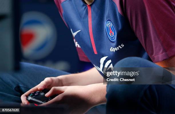 French player E-Sports, Lucas Cuillerier, gamertag 'DaXe' of the eSports team of Paris Saint-Germain uses a video game controller as he competes in...