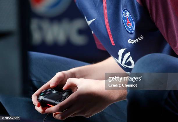 French player E-Sports, Lucas Cuillerier, gamertag 'DaXe' of the eSports team of Paris Saint-Germain uses a video game controller as he competes in...