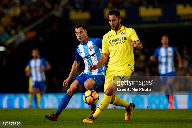 Juanpi of Malaga CF competes for the ball with Victor Ruiz of Villarreal CF during the La Liga match between Villarreal CF and Malaga CF at Estadio...