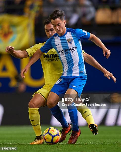 Victor Ruiz of Villarreal competes for the ball with Juan Pablo Anor of Malaga during the La Liga match between Villarreal and Malaga at Estadio De...