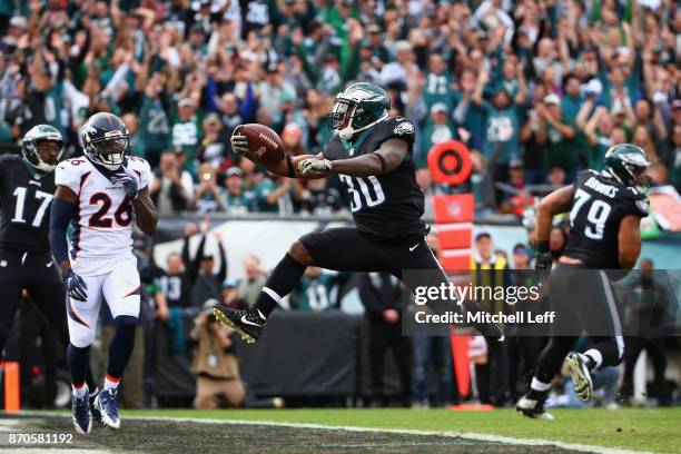 Running back Corey Clement of the Philadelphia Eagles leaps into the endzone to score a touchdown against the Denver Broncos during the first quarter...