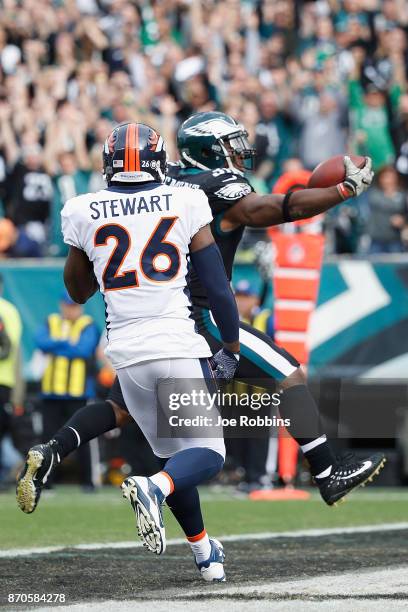 Running back Corey Clement of the Philadelphia Eagles leaps into the endzone to score a touchdown against free safety Darian Stewart of the Denver...