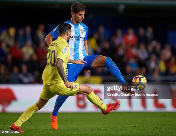 Roberto Soriano of Villarreal competes for the ball with Adrian Gonzalez of Malaga during the La Liga match between Villarreal and Malaga at Estadio...