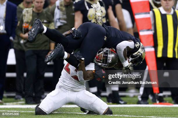 Alvin Kamara of the New Orleans Saints is tackled by Ryan Smith of the Tampa Bay Buccaneers during the first half of a game at Mercedes-Benz...