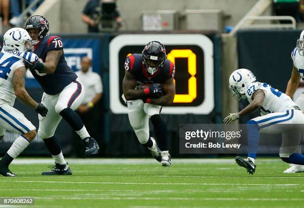 Lamar Miller of the Houston Texans runs the ball defended by Nate Hairston of the Indianapolis Colts in the second quarter at NRG Stadium on November...