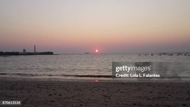 red sun and san sebastián castle in caleta beach, cadiz - playa de la caleta stock pictures, royalty-free photos & images